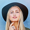 Portrait of a blonde woman wearing a black wide-brim hat