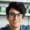 Portrait of a smiling man with curly hair and glasses
