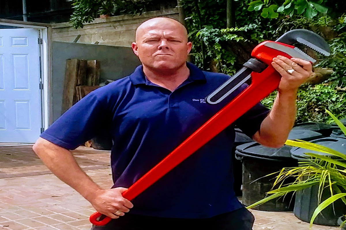 My Guy Plumbing plumber holding a large red pipe wrench outdoors in Bozeman MT