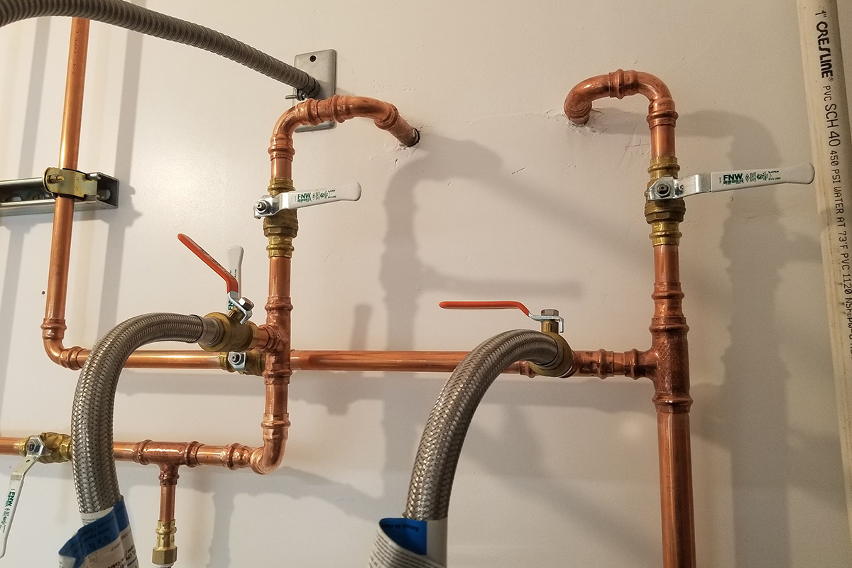 Copper water supply pipes and shutoff valves installed on a wall by My Guy Plumbing in Bozeman MT
